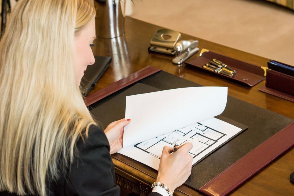 Details.jpg Frau Filusch von Vliegen & Partner Immobilien prüft einen Grundriss und macht Notizen zur Wertermittlung einer Immobilie